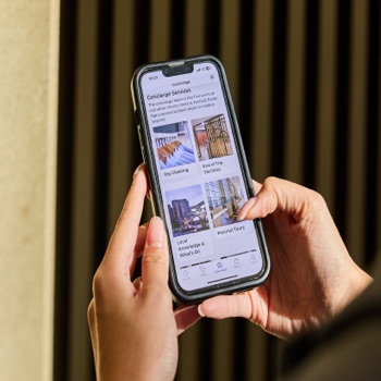 Person holding a mobile phone and browsing the concierge page on the app